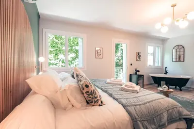 a bedroom with a large bed and a bath tub at Les Suites de l'Étang in Cucuron