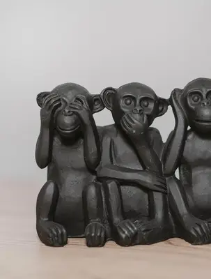 a group of three monkey statues sitting on a table at Les Suites de l'Étang in Cucuron
