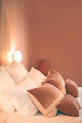 a bed with white pillows at Les Suites de l'Étang in Cucuron