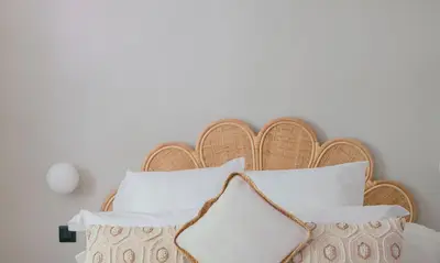 a bed with a wooden headboard with white pillows at Les Suites de l'Étang in Cucuron