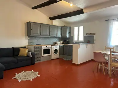 a living room with a couch and a kitchen at Namasté in Aix-en-Provence