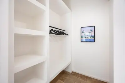 a white walk in closet with white shelves at La Suite Provençale in Aix-en-Provence