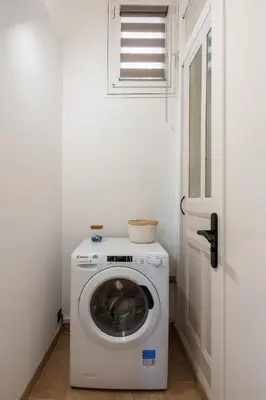a washing machine in a room with a door at La Suite Provençale in Aix-en-Provence