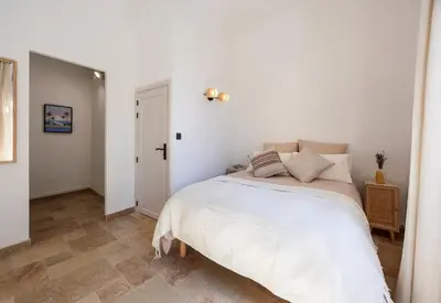 a white bedroom with a bed in a room at La Suite Provençale in Aix-en-Provence