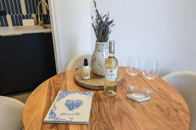 a wooden table with wine bottles and glasses on it at La Suite Provençale in Aix-en-Provence