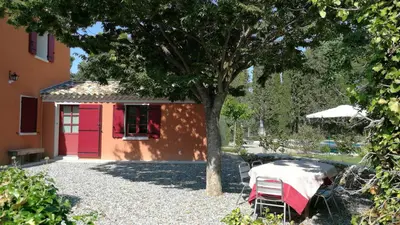 a table and chairs under a tree next to a building at Aix en Provence charmante villa piscine cadre verdoyant 6 personnes in Aix-en-Provence