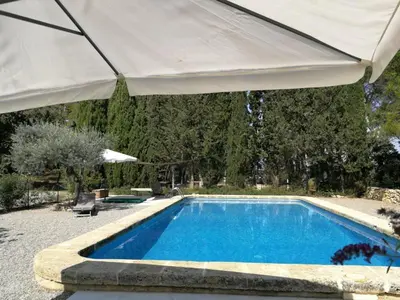 a swimming pool with a large white umbrella at Aix en Provence charmante villa piscine cadre verdoyant 6 personnes in Aix-en-Provence