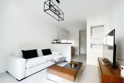 a living room with a white couch and a table at La Rotonde - Magnifique Appartement climatisé avec parking in Aix-en-Provence
