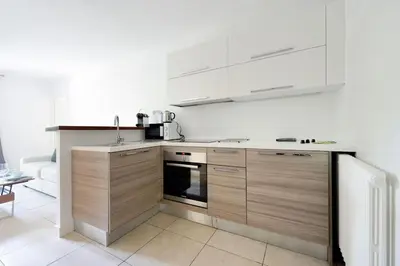 a kitchen with wooden cabinets and white appliances at La Rotonde - Magnifique Appartement climatisé avec parking in Aix-en-Provence
