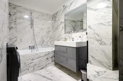 a white bathroom with a tub and a sink and a bath tubermott at La Rotonde - Magnifique Appartement climatisé avec parking in Aix-en-Provence