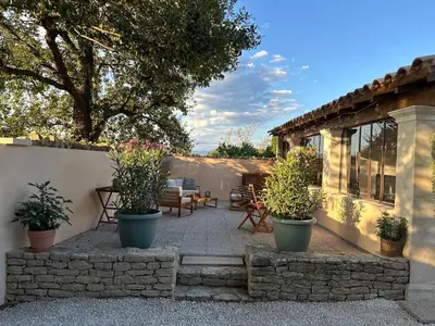 a patio with potted plants in front of a house at La Provence in Maubec
