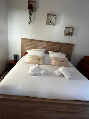 a large white bed with two towels on it at La Provence in Maubec