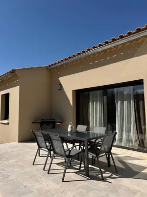 a black table and chairs in front of a house at Villa en Provence avec piscine in Mollégès