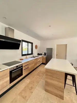 a kitchen with wooden cabinets and a white counter top at Villa en Provence avec piscine in Mollégès