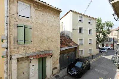 a black car parked in a street between two buildings at Studio Lavande in La Fare-les-Oliviers