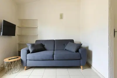 a blue couch sitting in a living room at Studio Lavande in La Fare-les-Oliviers