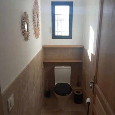 a bathroom with a toilet with a black seat and a window at Bastide 3 chambres 6personnes avec piscine sur Aix en Provence in Aix-en-Provence
