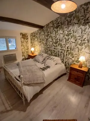 a bedroom with a bed with a floral wallpaper at Maison au coeur du Lubéron in Maubec