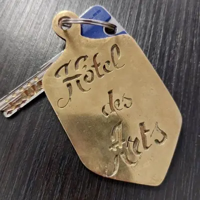 a brass key chain with a tag with the word fiesta istg at Hôtel des ARTS Aix in Aix-en-Provence