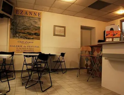 a room with chairs and tables in a restaurant at Hôtel des ARTS Aix in Aix-en-Provence