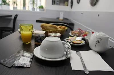 a table with a teapot and a cup and plates of food at Hôtel des ARTS Aix in Aix-en-Provence