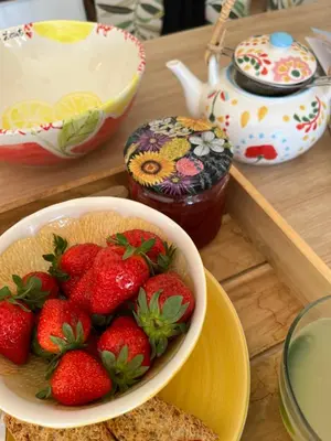 a bowl of strawberries on a table with a bowl of honey at Villa BELVENTO, superbe villa au calme, piscine, vue incroyable ! in Ventabren