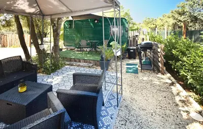 a patio with a swing and a green trailer at Gorgeous Stacaravan in Pernes-les-Fontaines