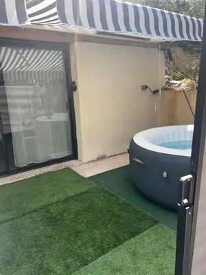 a bathroom with a tub on a patio with green grass at L'Escale in Meyreuil