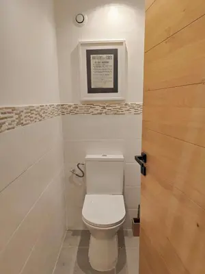 a bathroom with a toilet and a picture on the wall at L'Escale in Meyreuil