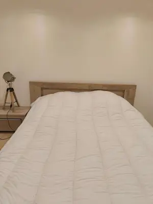 a bedroom with a bed with a white blanket at L'Escale in Meyreuil