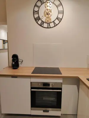 a clock on the wall above a kitchen counter at L'Escale in Meyreuil