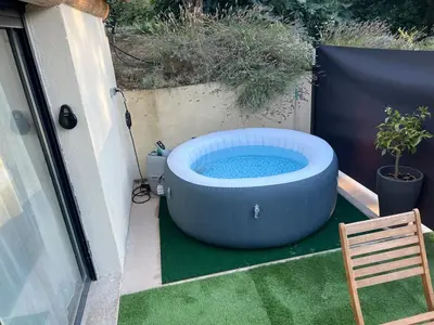 a large hot tub on a patio with a chair at L'Escale in Meyreuil