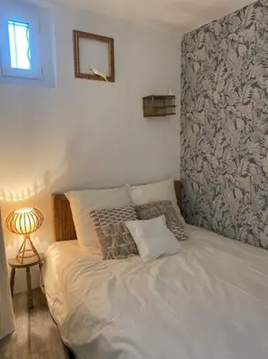 a white bed in a bedroom with a side table at Calussine maison provençale in Pernes-les-Fontaines