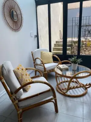 a living room with two chairs and a table at Calussine maison provençale in Pernes-les-Fontaines