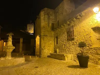 an old stone building with a clock tower at night at Calussine maison provençale in Pernes-les-Fontaines