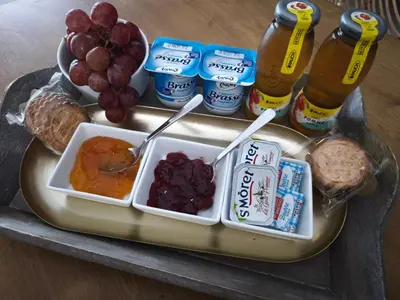 a tray of food with grapes and bread and drinks at Chambre chez l'habitant à Pernes les Fontaines in Pernes-les-Fontaines