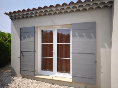 a window on the side of a white house at Chambre chez l'habitant à Pernes les Fontaines in Pernes-les-Fontaines