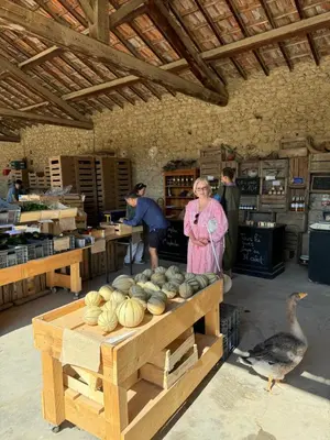 a woman standing in a room with a table with pumpkins at La Bergerie de Chateau Fontvert in Lourmarin