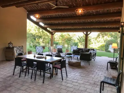 a patio with a table and chairs and a couch at La Bergerie de Chateau Fontvert in Lourmarin