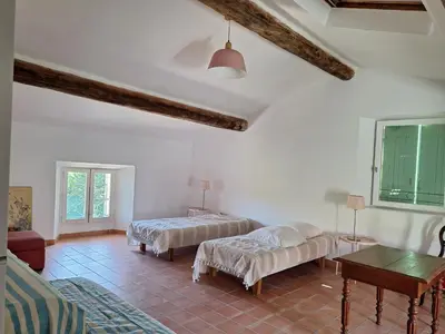 a living room with two beds and a table at La Maison Cassée in Malemort-du-Comtat