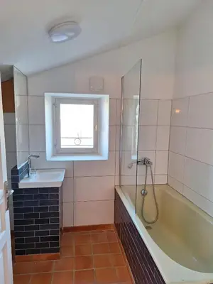 a bathroom with a sink and a tub and a window at La Maison Cassée in Malemort-du-Comtat