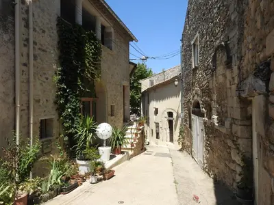 an alley in an old building with plants on the side at la capelette in Céreste