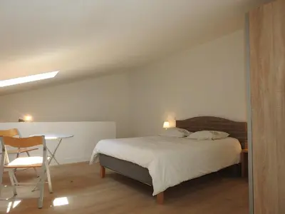 a bedroom with a bed and a table and a chair at la capelette in Céreste