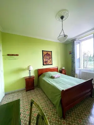 a bedroom with a bed with green walls and a window at Chambre de 2 personnes dans Mas de Lubéron in Robion en Luberon