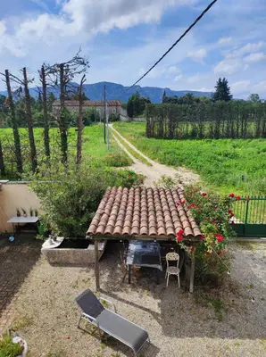 a picnic table in a yard with a field at Chambre de 2 personnes dans Mas de Lubéron in Robion en Luberon