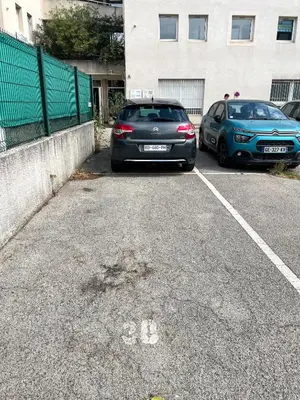 two cars parked in a parking lot next to a building at Studio Coconing Aix-en-Provence in Aix-en-Provence