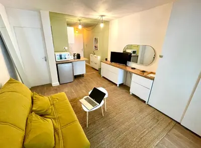 a living room with a yellow couch and a mirror at Studio Coconing Aix-en-Provence in Aix-en-Provence