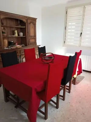 a red table with chairs and a red table cloth at La garenne basse chez Sylvie in Saint-Didier