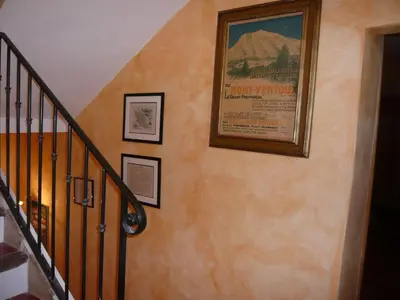 a staircase with a picture on the wall and a stair case at Le Mas Saint Jacques in Crillon-le-Brave