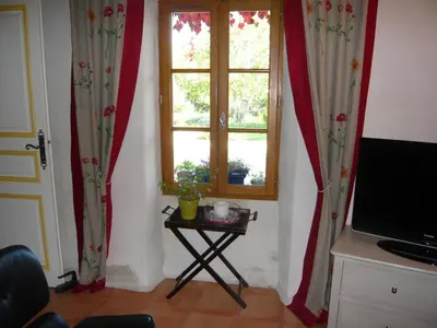 a room with curtains and a table with a window at Le Mas Saint Jacques in Crillon-le-Brave